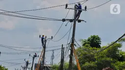 Petugas melakukan perawatan kabel listrik di kawasan Kosambi, Tangerang, Senin (9/1/2023). Pemerintah tidak menaikkan tarif listrik periode Januari hingga Maret 2023 untuk 13 golongan pelanggan non subsidi. (Liputan6.com/Angga Yuniar)