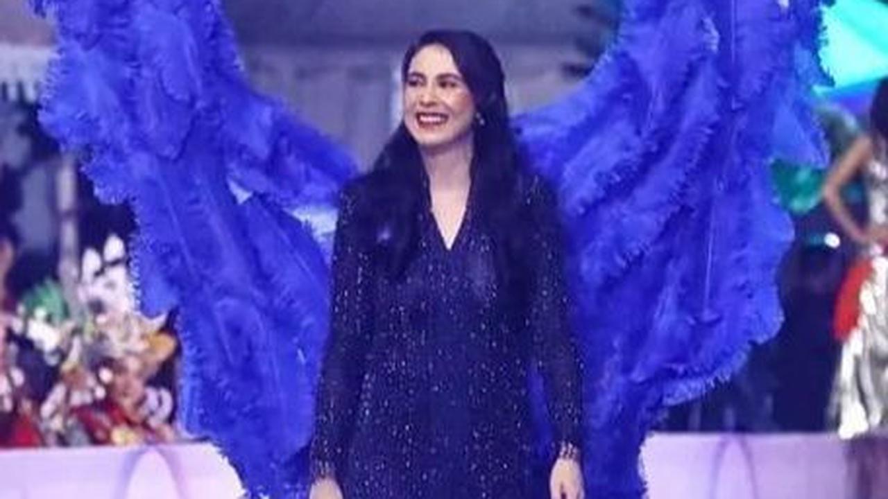 Arumu Bachsin tampil dalam balutan busana hitam dengan aksesoris sayap berwarna biru