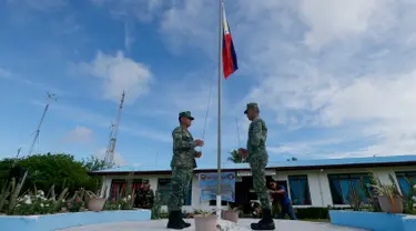  Tentara Filipina menaikan bendera saat mengikuti upacara di Pulau Thitu, Kepulauan Spratly, Laut China Selatan, Jumat (21/4). Pengibaran bendera Filipina yang sebelumnya dibatalkan  Presiden Duterte  akhirnya dilaksanakan. (AP Photo / Bullit Marquez)