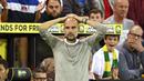 Pelatih Manchester City, Pep Guardiola, tampak kecewa usai ditaklukkan Norwich City pada laga Premier League di Stadion Carrow Road, Sabtu (14/9). Norwich City menang 3-2 atas Manchester City. (AP/Joe Giddens)