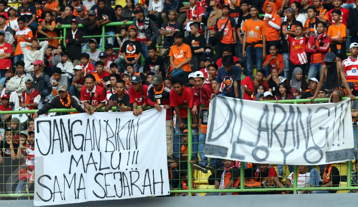 Suporter membentangkan spanduk protes usai menyaksikan laga Persija melawan Mitra Kukar pada lanjutan Liga 1 Indonesia di Stadion Patriot Candrabhaga, Bekasi, Minggu (14/5). Laga kedua tim berakhir imbang 1-1. (Liputan6.com/Helmi Fithriansyah)