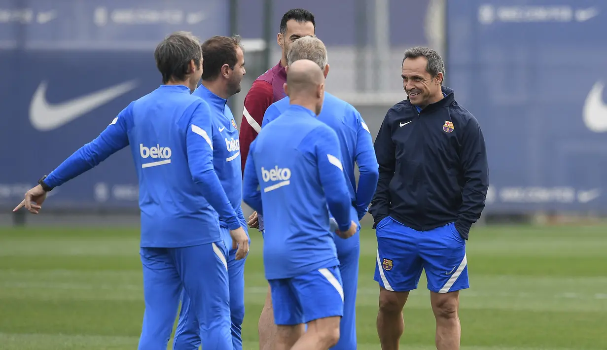 Pelatih interim Barcelona, Sergi Barjuan (kanan) berbicara dengan staf teknis selama sesi latihan menjelang lanjutan Liga Spanyol melawan Deportivo Alaves di Barcelona, Kamis (29/10/2021). Latihan pertama Barcelona dipimpin Sergi Barjuan sambil nunggu kedatangan Xavi Hernandez. (Josep LAGO/AFP)