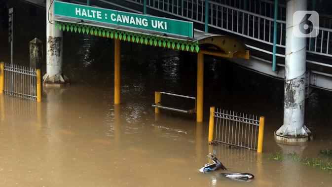 Sebuah motor tergeletak di Jalan Di Panjaitan dekat Halte Transjakarta Cawang Soetoyo yang tergenang banjir, Jakarta, Rabu (1/1/2020). Hujan yang mengguyur Jakarta sejak Selasa sore (31/12/2019) mengakibatkan banjir di sejumlah titik di Jakarta. (Liputan6.com/Helmi Fithriansyah)