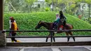 Wisatawan menaiki kuda di Cimory Dairyland, Puncak, Bogor, Jawa Barat, Minggu (31/10/2021). Pelonggaran PPKM dimanfaatkan masyarakat untuk berlibur ke tempat wisata dengan tetap memberlakuan protokol kesehatan COVID-19. (Liputan6.com/Faizal Fanani)