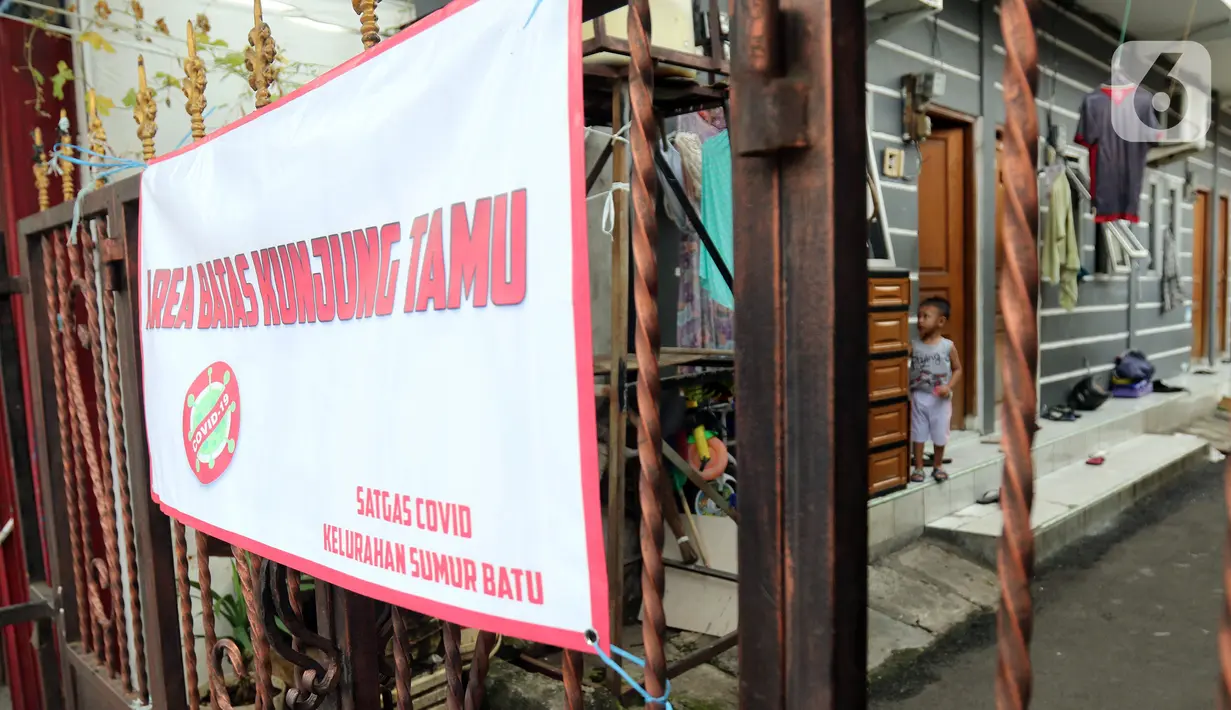 Spanduk pemberitahuan area batas kunjung tamu terpasang pada pagar di kawasan Intan Berduri, Sumur Batu, Jakarta, Rabu (9/06/2021). Kelurahan Sumur Batu memberlakukan mikro lockdown di RT 1, RT 2 dan RT di RW 03 setelah 34 warga positif COVID-19. (Liputan6.com/Herman Zakharia)