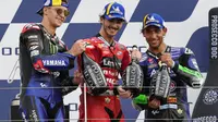 Pembalap Ducati, Francesco Bagnaia (tengah), menjuarai MotoGP San Marino, Minggu (19/9/2021). Dia berpose di podium bersama Fabio Quartararo (kiri) dan Enea Bastianini. (AP Photo/Antonio Calanni)