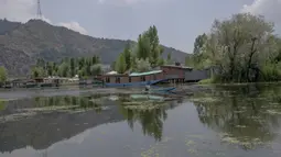 Seorang pria mengendarai shikara atau gondola tradisional untuk menangkap ikan di Danau Dal, Srinagar, Kashmir, India, Rabu (22/7/2020). Danau Dal terkenal dengan airnya yang jernih dan tenang. (AP Photo/Dar Yasin)