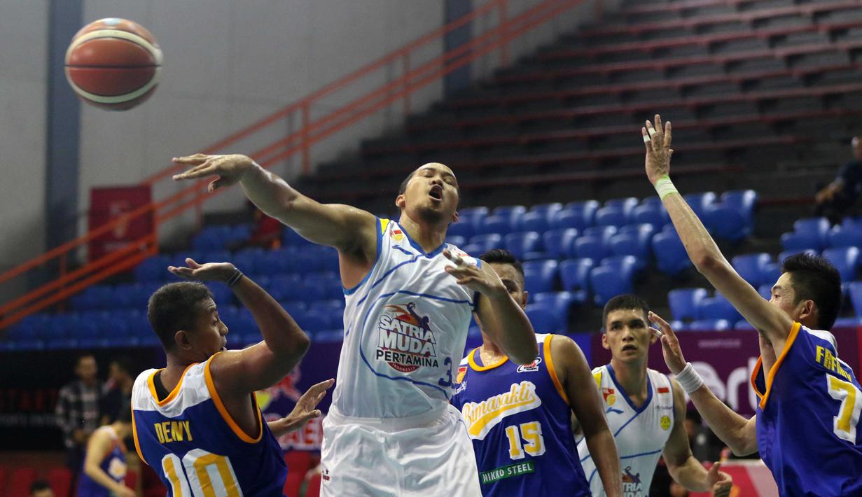 Aksi Pemain Satria Muda, Arki wisnu (tengah) saat melewati hadangan pemain Bimasakti pada laga IBL Reguler Season di Hall A Senayan, Jakarta, Senin (11/1/2016). Satria Muda menang 55-33. (Bola.com/Nicklas Hanoatubun)