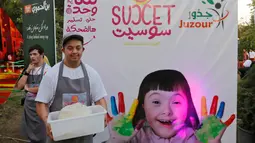 Seorang anak down syndrome Abdel Rahman bekerja di kedai kopi Sucet  selama festival "Sham gather us" di Damascus (11/7). Enam belas anak laki-laki dan perempuan down syndrome bekerja di Cafe Sucet melayani pelanggan. (AFP Photo/Louai Beshara)