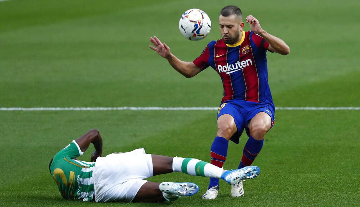 Bek Barcelona, Jordi Alba, berusaha melewati pemain Real Betis, Emerson, pada laga La Liga di Stadion Camp Nou, Sabtu (7/11/2020). Barca menang dengan skor 5-2.(AP/Joan Monfort)