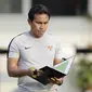 Pelatih Timnas Indonesia, Bima Sakti, mengamati strategi saat latihan di Universitas Kasetsart, Bangkok, Kamis (15/11). Latihan ini persiapan jelang laga Piala AFF 2018 melawan Thailand. (Bola.com/M. Iqbal Ichsan)