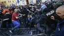 Pengunjuk rasa (kiri) berkelahi dengan polisi anti huru-hara saat aksi protes oleh pemilik restoran dan aktivitas bisnis lainnya di luar parlemen di Piazza Montecitorio di Roma, Selasa (6/4/202). Mereka memprotes tindakan pembatasan untuk mengatasi lonjakan kasus COVID-19. (Filippo MONTEFORTE/AFP)