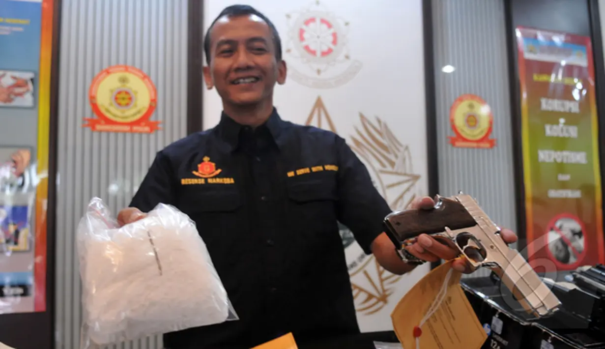 Petugas kepolisian memperlihatkan barang bukti berupa paket sabu dan senjata api dari tersangka pengedar sabu di kawasan Cawang, Jakarta, Jumat (20/2/2015). (Liputan6.com/Johan Tallo)