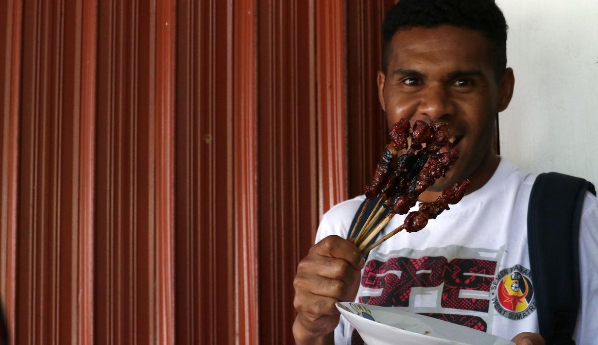 Pemain Semen Padang, Vendry Mofu  antusias menunjukan sate kambing Sido Mampir Putro di Solo, Minggu(13/12/2015). (Bola.com/Nicklas Hanoatubun)