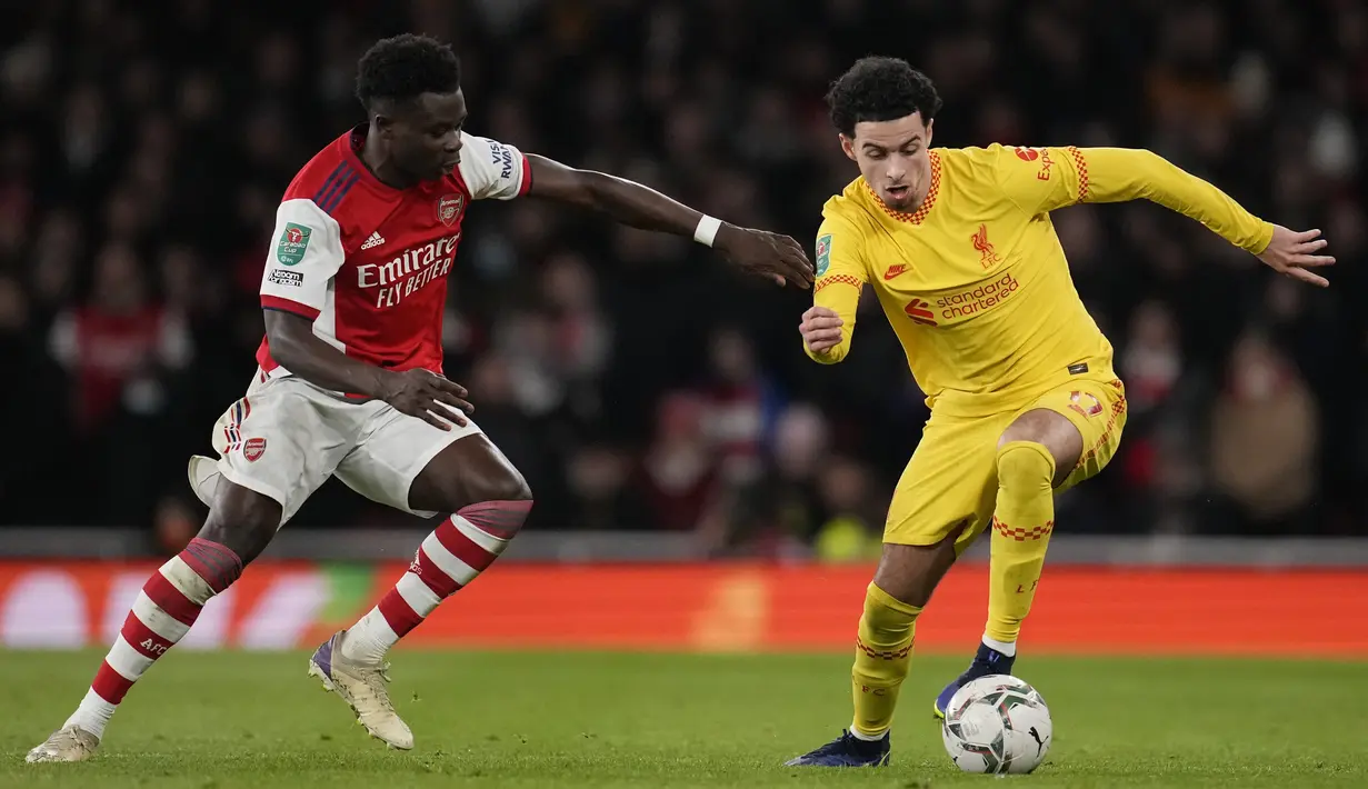 Gelandang Liverpool, Curtis Jones mengontrol bola dari kawalan bek Arsenal, Bukayo Saka pada pertandingan leg kedua semifinal Piala Liga Inggris di Stadion Emirates di London, Jumat (21/1/2022). Dengan kemenangan ini Liverpool berhasil melaju ke final. (AP Photo/Matt Dunham)