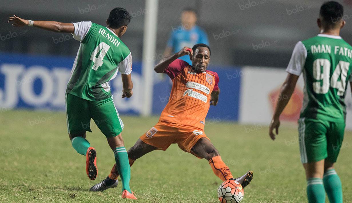 Pemain PS TNI, Hendri Aprilianto, berusaha melewati gelandang Borneo FC, Gerald Pangkali. Kemenangan PS TNI ini membuat posisi mereka naik ke peringkat 14 klasemen TSC 2016. (Bola.com/Vitalis Yogi Trisna)