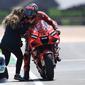 Pembalap Ducati, Pecco Bagnaia disambut sang kekasih usai finis kedua MotoGP Portugal. (PATRICIA DE MELO MOREIRA / AFP)