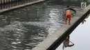 Salah satu petugas UPK Badan Air Dinas Lingkungan Hidup DKI Jakarta mengangkut ceceran sampah di Kali Cideng, Jakarta, Jumat (9/11). Pembersihan untuk mencegah terjadinya penumpukan sampah saat musim hujan di Jakarta. (Liputan6.com/Helmi Fithriansyah)
