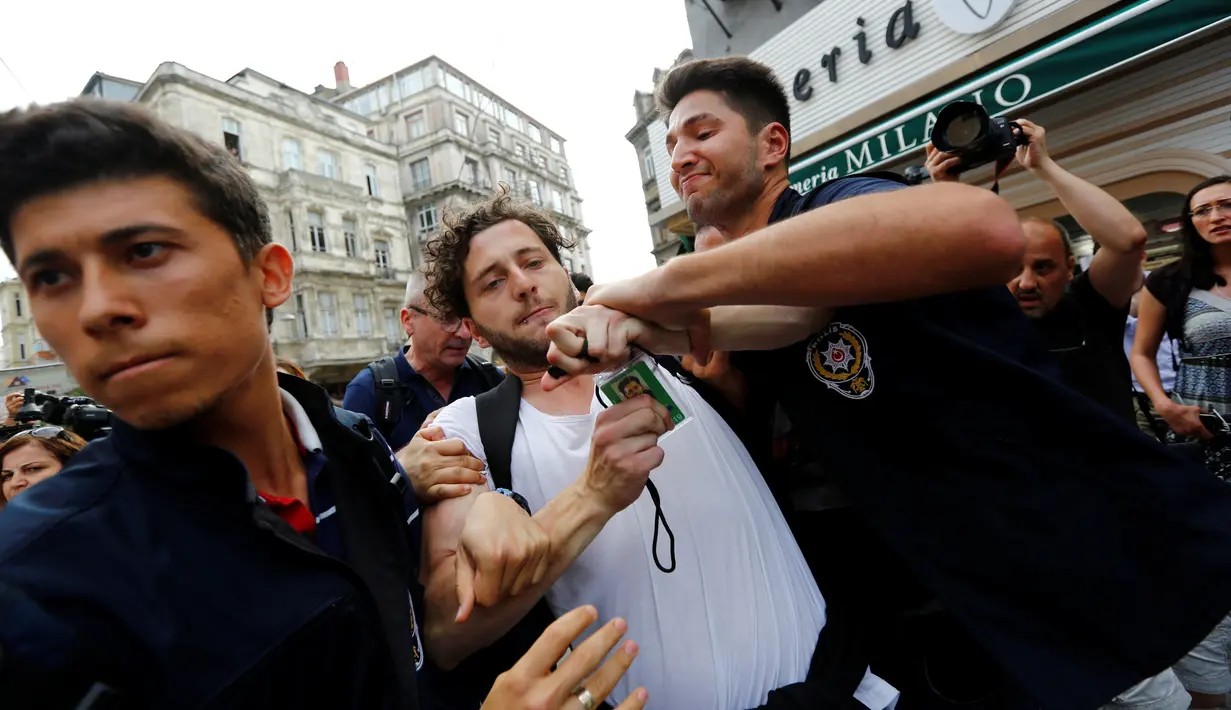 Polisi berpakaian preman menahan Felix Banaszak, anggota Partai Green Jerman ketika mencoba melancarkan pawai tahunan LGBTI, yang telah dilarang pemerintah, di Istanbul, Turki, Minggu (26/6). (REUTERS/Murad Sezer)