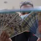 Petugas menunjukkan uang rupiah di penukaran uang, Jakarta, Senin (9/11/2020). ). Nilai tukar rupiah terhadap dolar AS bergerak menguat pada perdagangan di awal pekan ini Salah satu sentimen pendorong penguatan rupiah kali ini adalah kemenangan Joe Biden atas Donald Trump. (Liputan6.com/Angga Yuniar
