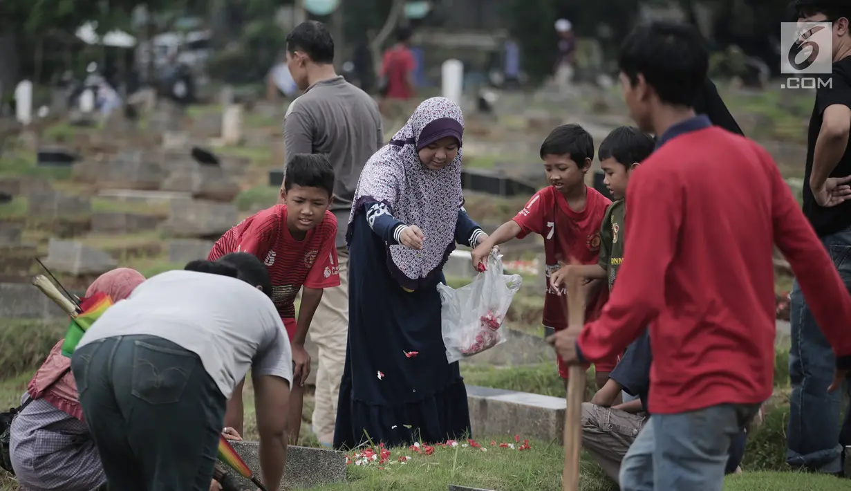 Warga menabur bunga di pusara saat berziarah kubur di Tempat Pemakaman Umum (TPU) Menteng Pulo, Jakarta, Minggu (28/4/2019). Sepekan menjelang datangnya bulan Ramadan, banyak masyarakat melakukan ziarah kubur mendoakan mendiang keluarga dan kerabat mereka. (Liputan6.com/Faizal Fanani)