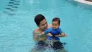 Ardina dan suami sedang menikmati menjadi orang tua. Tak hanya bermain bersama ular, Arie juga ajak si bungsu untuk berenang. (Instagram.com/ardinarasti6)