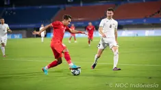 Pemain Timnas Indonesia U-24 Egy Maulana Vikri menggiring bola mencoba melewati pemain Timnas Kirgistan Elaman Akylbekov pada pertandingan sepak bola putra Grup F Asian Games 2023 di Zhejiang Normal University East Stadium, Jinhua, China, Selasa (19/9/2023). Indonesia menang 2-0 atas Kirgistan. (Kredit Foto: NOC Indonesia/Naif Al&rsquo;As)