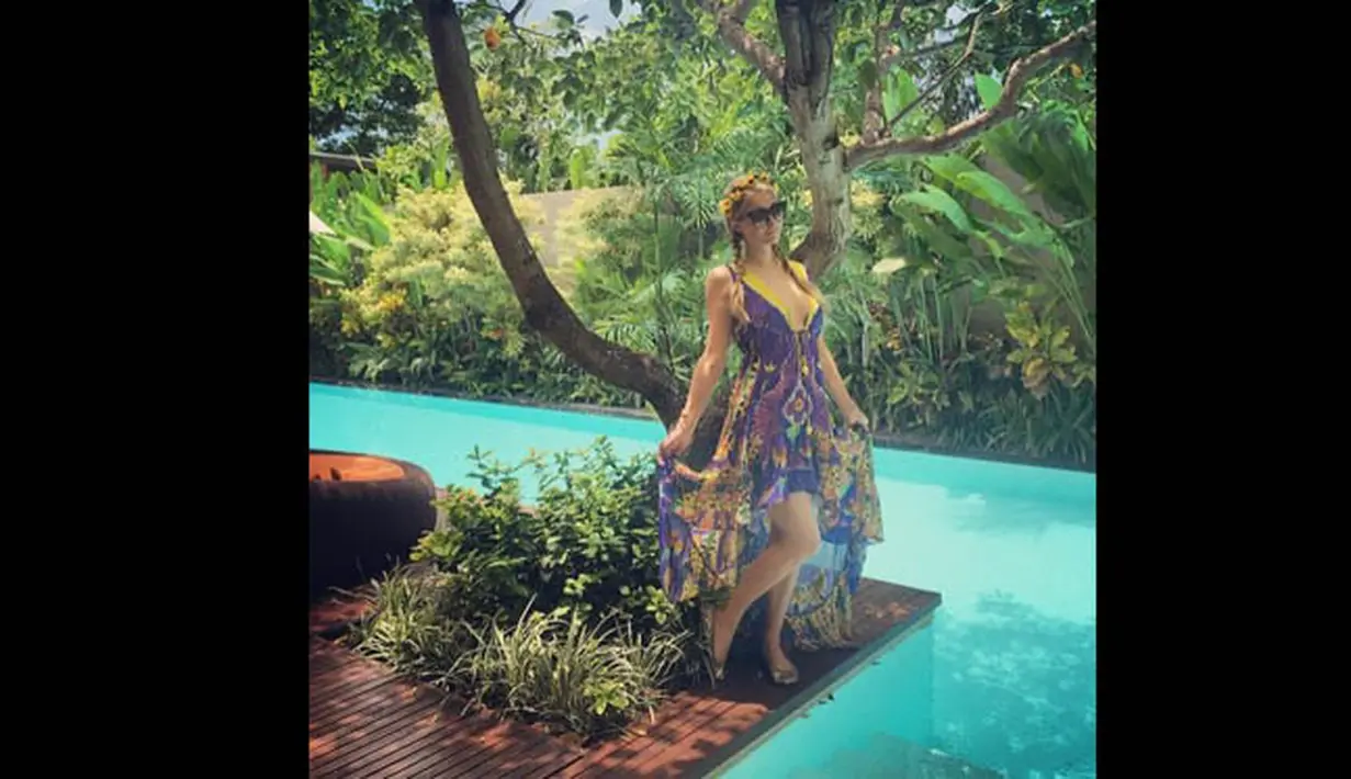 Paris Hilton terlihat menikmati suasana berlibur di pinggir kolam renang di vila tempatnya menginap. (instagram.com/parishilton)