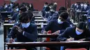 Siswa yang mengenakan masker mengikuti ujian kenaikan kelas XII di lapangan sekolah di Kathmandu, Nepal, Senin (23/11/2020). Nasib sekitar 450.000 siswa kelas XII digantung akibat COVID-19 saat ujian yang dijadwalkan mulai 20 April ditunda karena lockdown pada 24 Maret lalu. (PRAKASH MATHEMA/AFP)