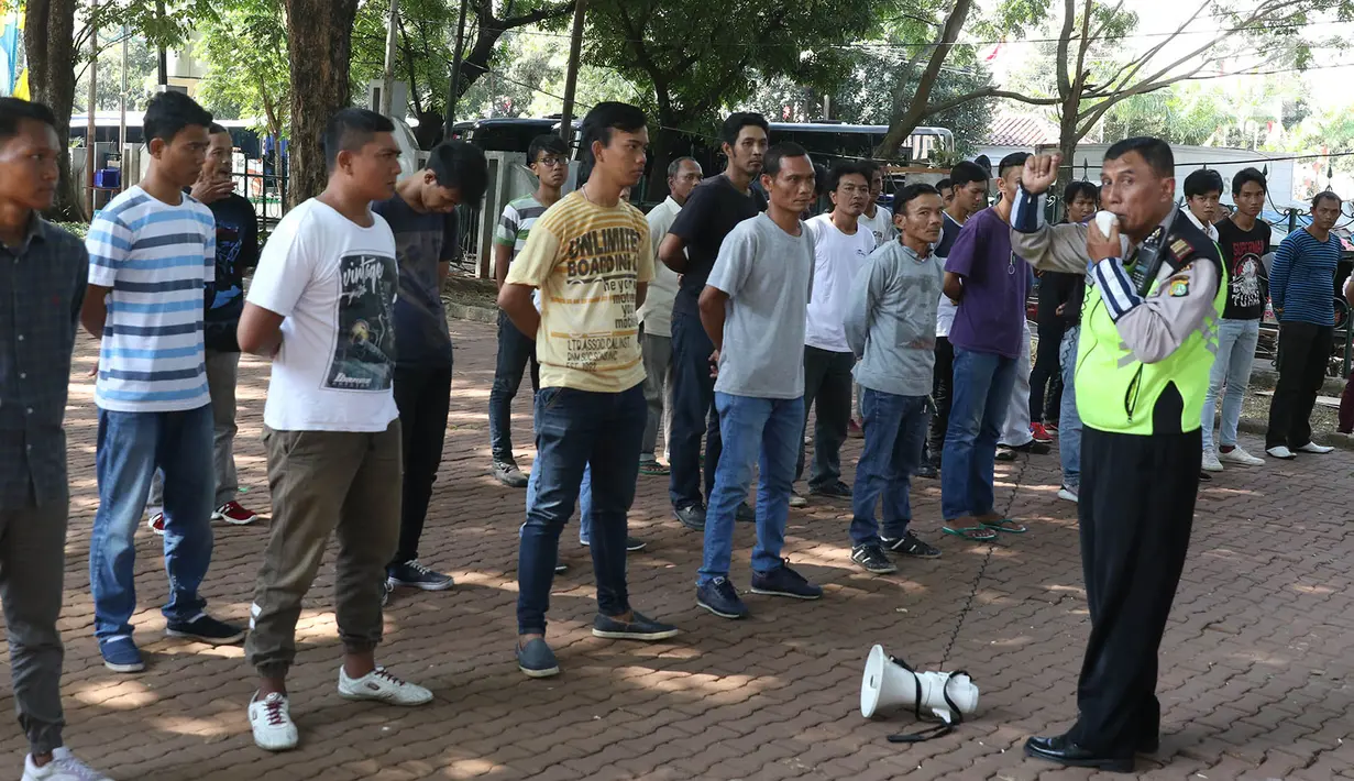 Petugas kepolisian memberikan pelatihan kepada 'Pak Ogah' atau calon Sukarelawan Pengatur Lalu Lintas (supeltas) di Lapangan Banteng, Jakarta, Rabu (23/8). Mereka diwajibkan menjalani serangkaian pelatihan selama lima hari (Liputan6.com/Immanuel Antonius)