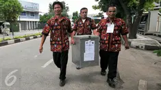 Petugas TPS membawa kotak suara yang nantinya akan dikumpulkan ke kelurahan sebelum didistribusikan kembali ke Kecamatan, Depok, (9/12). TPS di Kota Depok adalah sebanyak 3.235 TPS tersebar di 63 kelurahan dan 11 kecamatan. (Liputan6.com/Yoppy Renato)