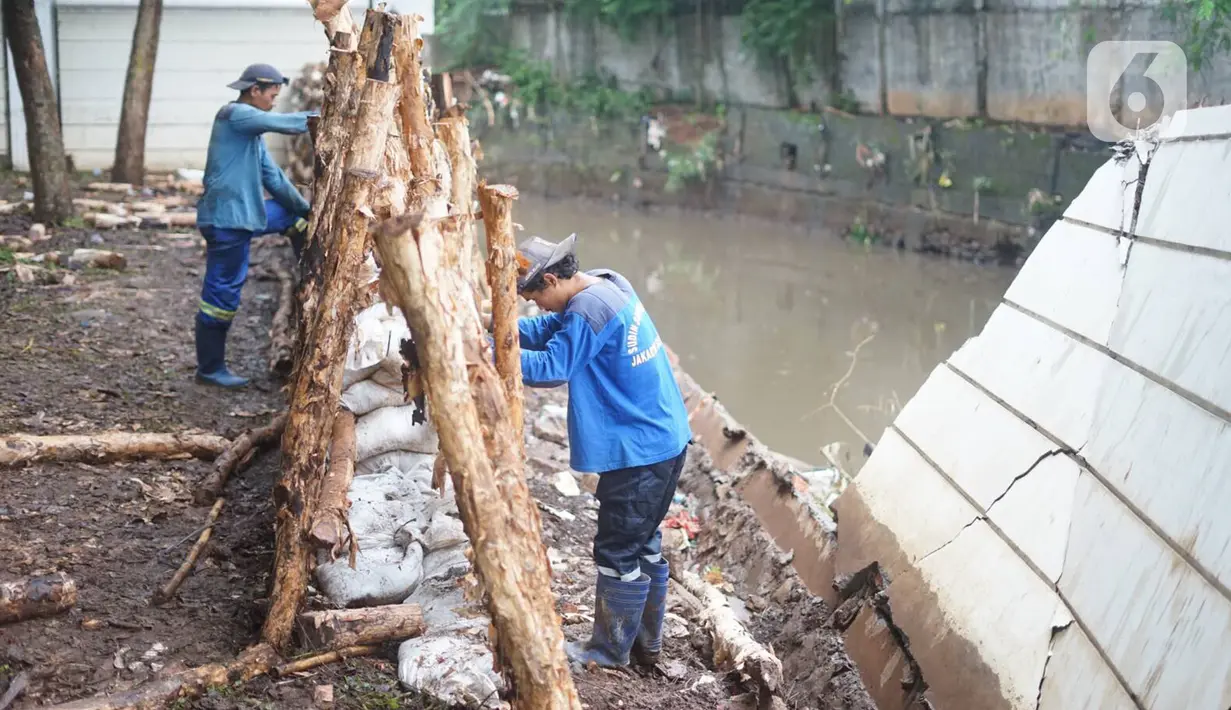 Petugas Sudin SDA Jakarta Selatan memperbaiki tanggul Kali Krukut yang jebol di Jalan Perumahan Kemang Jaya, Bangka, Jakarta, Rabu (8/1/2020). Tanggul jebol akibat tak kuat menahan derasnya air kiriman dari hulu serta hujan deras yang mengguyur kawasan tersebut. (Liputan6.com/Immanuel Antonius)