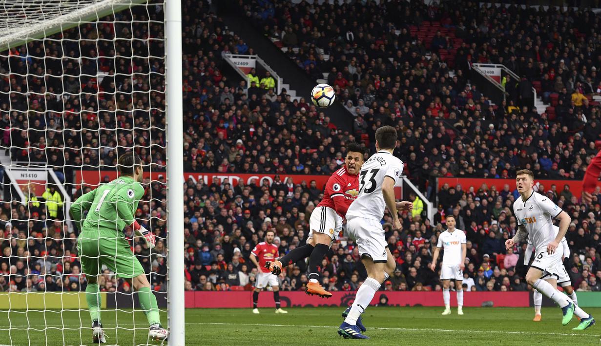 Gaya pemain Manchester United, Alexis Sanchez saat menyundul bola ke gawang Swansea City pada laga Premier League di Old Trafford, (31/3/2018).  Manchester United menang 2-0. (Anthony Devlin/PA via AP)