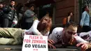 Aktivis PETA berdandan menyerupai zombie sambil berbaring di jalan depan sebuah restoran cepat saji di Sydney, Australia, Kamis (15/6). Aksi tersebut sebagai bentuk protes terhadap konsumsi daging dan mempromosikan vegetarian. (SAEED KHAN/AFP)