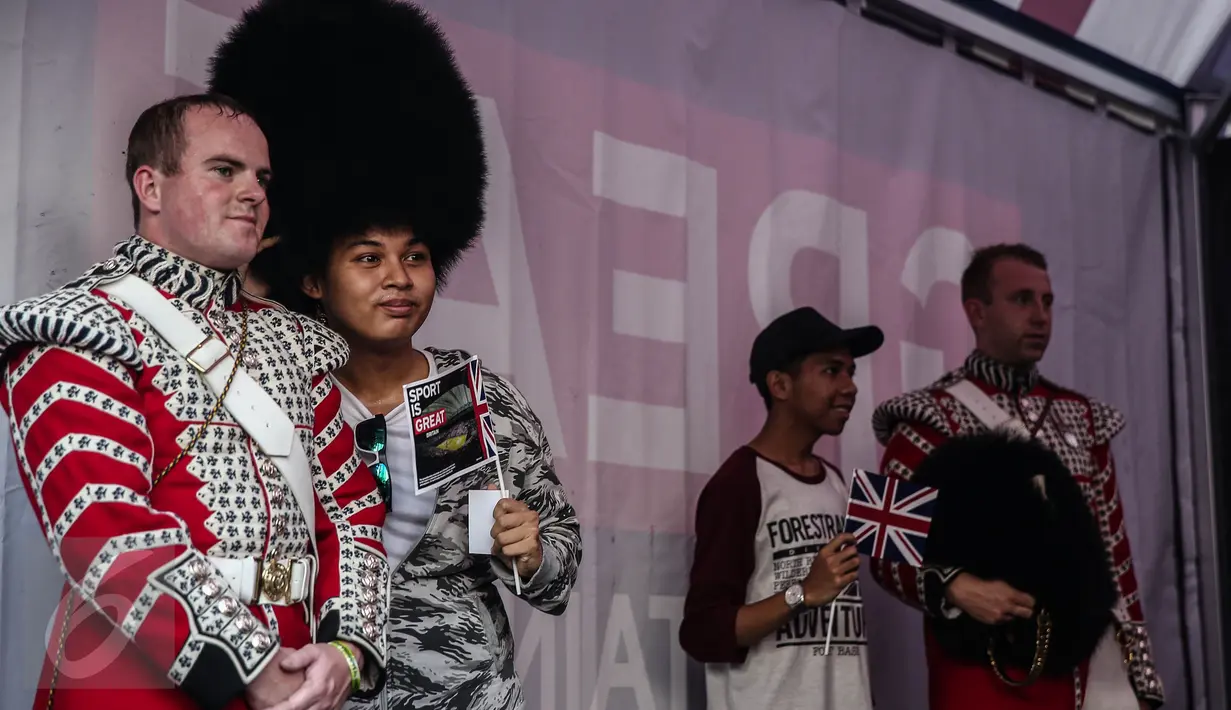 Seorang warga berpose disamping pasukan Scotts Guard alias penjaga Istana Inggris, usai beraksi di sela kegiatan Car Free Day (CFD) di kawasan Bundaran HI, Jakarta, Minggu (5/6). (Liputan6.com/Faizal Fanani)