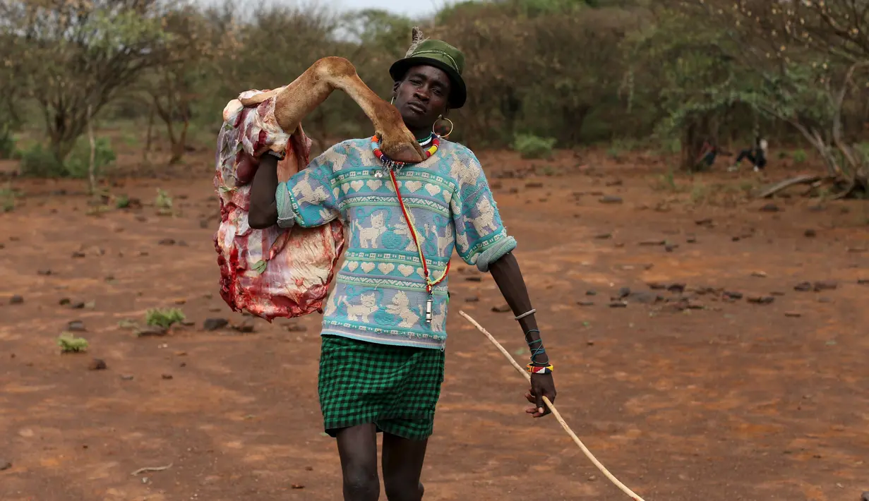 Pria Pokot membawa potongan tubuh hewan yang diburu untuk persyaratan menjalani upacara Sapana di Baringo County, Kenya , (20/1). Mereka para pria wajib membawakan hewan - hewan ternak untuk pasangannya bila ingin menikah. (REUTERS / Siegfried Modola)