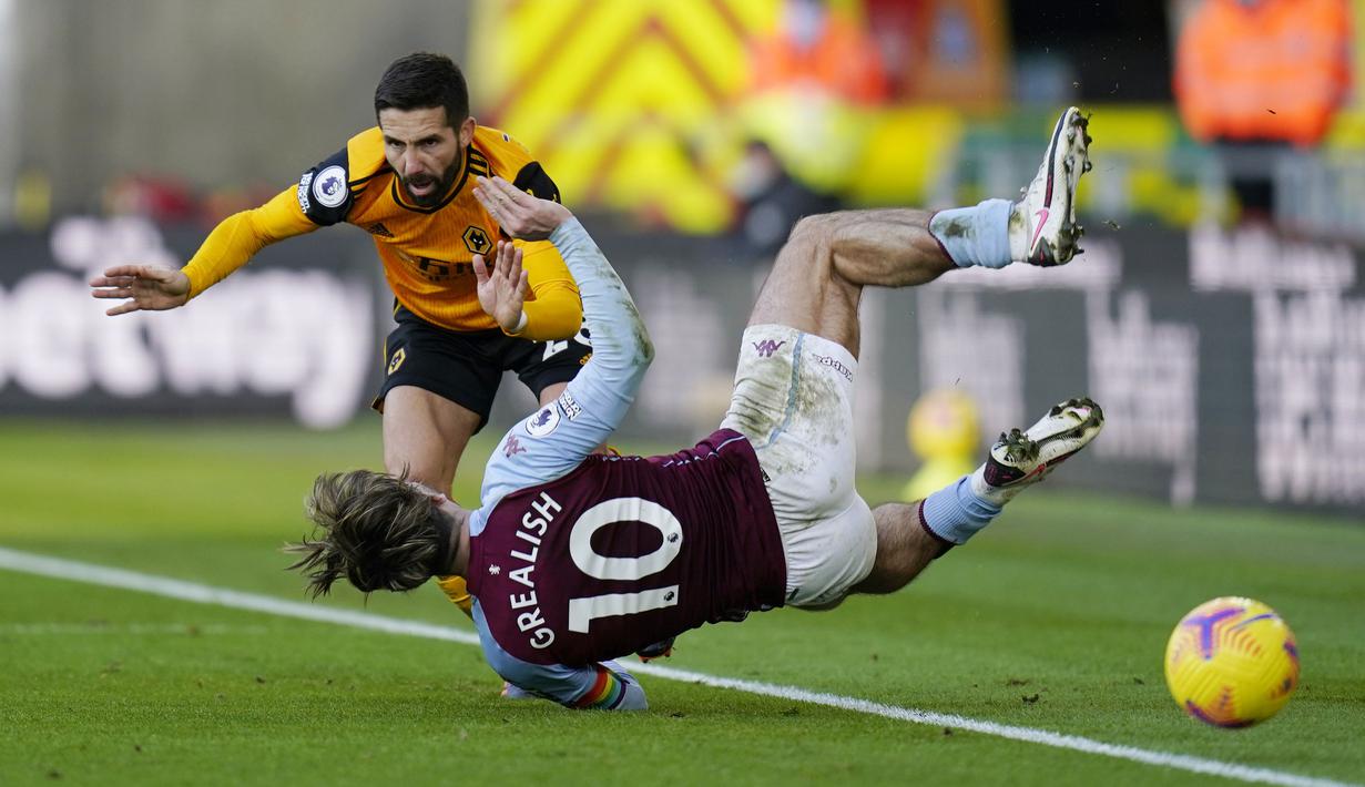 Pemain Aston Villa, Jack Grealish, terjatuh saat berebut bola dengan pemain Wolverhampton Wanderers, Joao Moutinho, pada laga Liga Inggris di Stadion Molineux, Minggu (13/12/2020). Aston Villa menang dengan skor 0-1. (Tim Keeton/Pool/AFP)