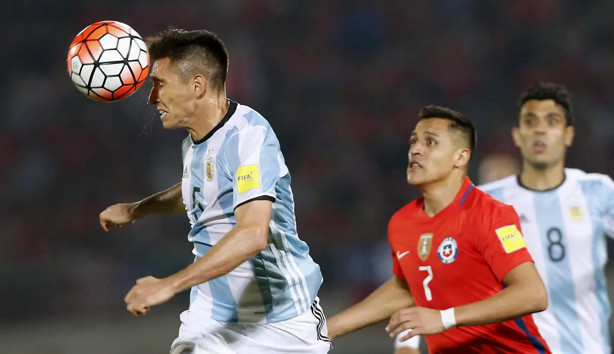 Pemain Argentina, Matias Kranevitter menyundul bola saat dikejar Alexis Sanchez pada laga kualifikasi Piala Dunia 2018 zona CONMEBOL di Stadio Nacional Julio Martinez Pradanos, Santiago, Jumat (25/3/2016) pagi WIB.  (REUTERS/Rodrigo Garrido)