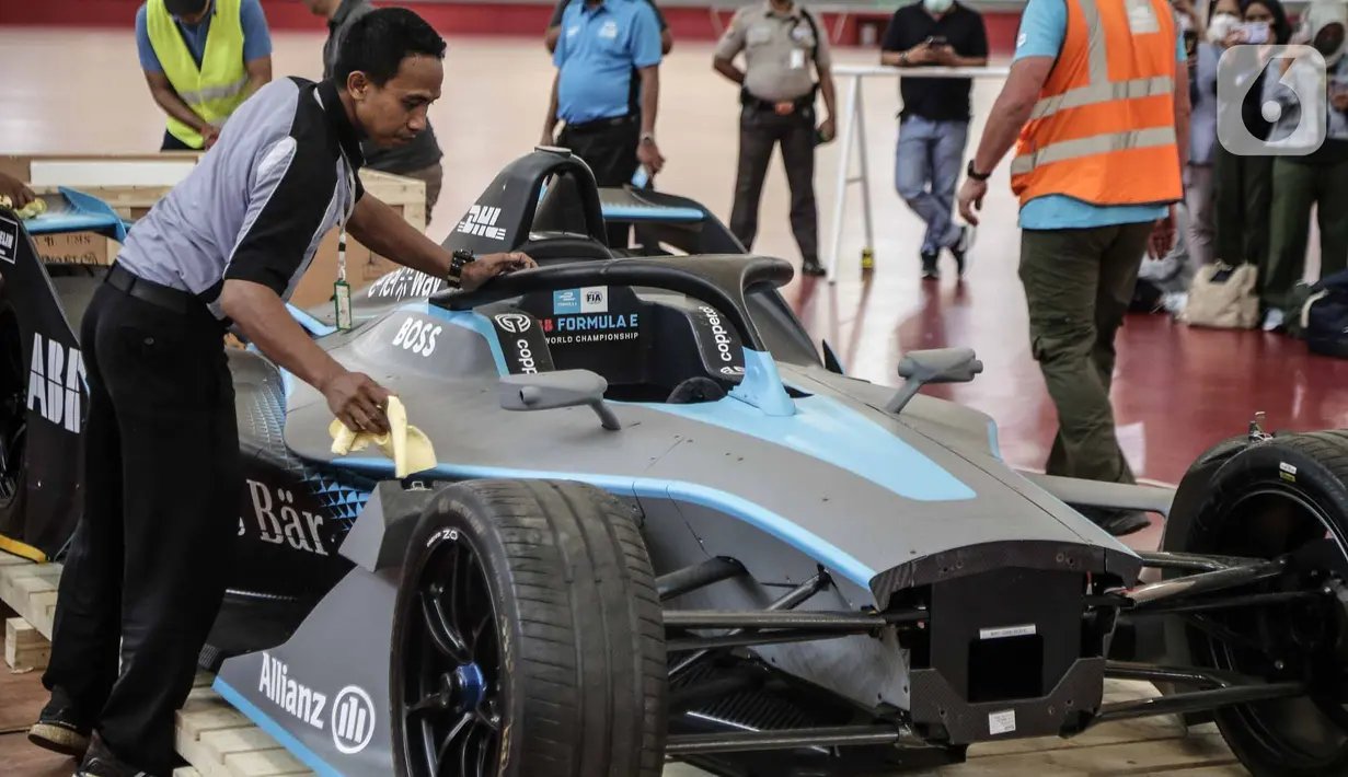 Petugas mengelap replika mobil Formula E setelah dibuka untuk kali pertama di Stadion Balap Sepeda Velodrome, Rawamangun, Jakarta Timur, pada Kamis (26/5/2022). Ini merupakan replika salah satu mobil Formula E yang akan mengaspal di Sirkuit Ancol pada 4 Juni mendatang. (Liputan6.com/Faizal Fanani)