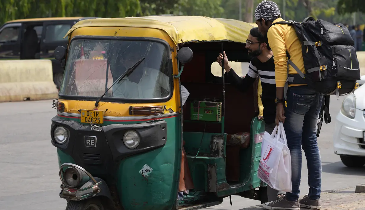 Penumpang bernegosiasi dengan pengemudi becak di luar stasiun kereta api selama pemogokan oleh operator transportasi swasta di New Delhi, India, 18 April 2022. Berbagai serikat pekerja bajaj dan taksi di ibu kota mogok menuntut subsidi untuk gas alam terkompresi. (AP Photo/Manish Swarup)