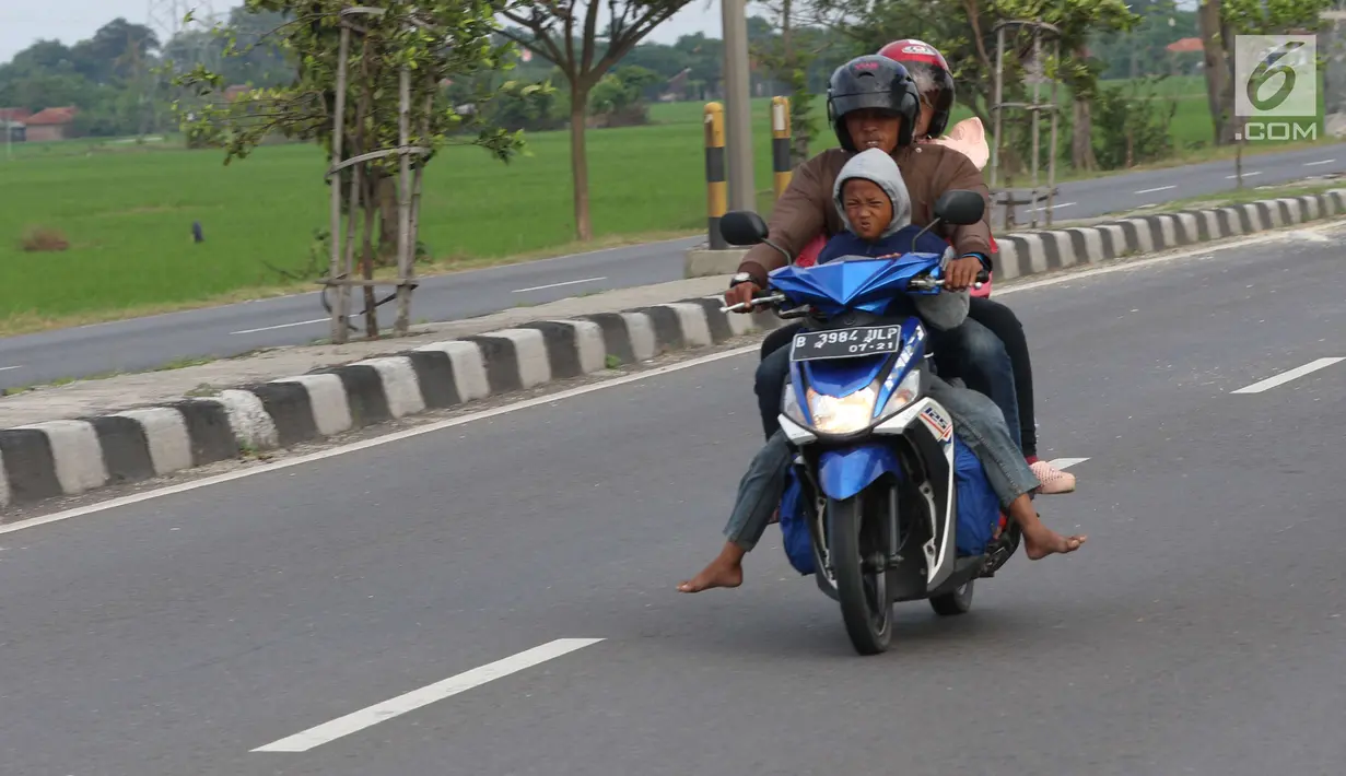 Pemudik sepeda motor dengan membawa anak melintasi Jalur Pantura Cirebon, Jawa Barat, Kamis, (29/6). Memasuki H+4 Lebaran jalur Pantura Cirebon mengarah ke Jakarta mulai dipadati pemudik pengguna kendaraan bermotor roda dua (Liputan6.com/Helmi Afandi)