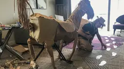 David Marriott berpose dengan kuda kertasnya Russell di kamar hotelnya di Brisbane, Australia, 3 April 2021. Saat berada dalam kamar hotel untuk karantina, direktur seni di iklan TV itu bosan dan mulai membuat pakaian koboi dari kantong kertas makanannya yang dikirimkan. (David Marriott via AP)