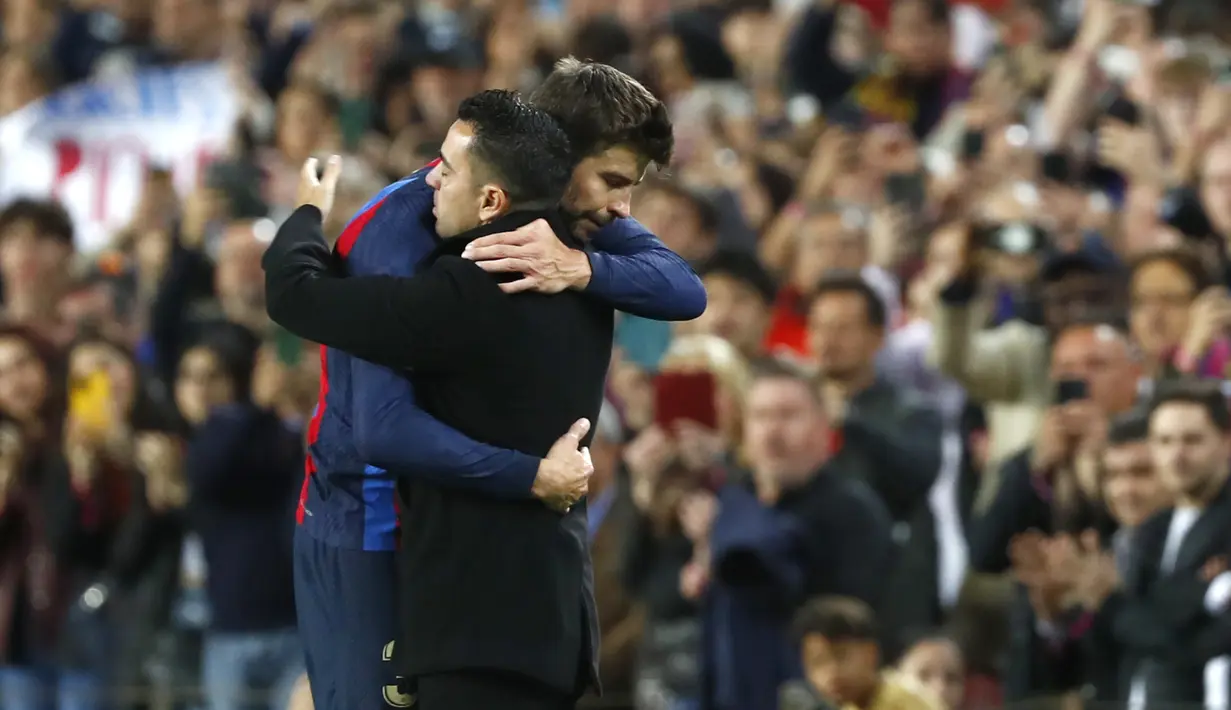 k Barcelona, Gerard Pique memeluk pelatih Xavi Hernandez setelah pertandingan melawan Almeria di stadion Camp Nou di Barcelona, Spanyol, Minggu (6/11/2022). Jersey merah biru khas Barcelona diberikan untuk Pique, lengkap dengan sematan kata Sempr3 di bagian dada. Kata Sempr3 sendiri berarti 'Selalu'. (AP Photo/Joan Monfort)