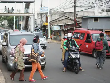Pejalan kaki menyeberangi jalan di depan Stasiun Lenteng Agung, Jakarta, Senin (4/11/2019). Meski telah tersedia JPO, sebagian pejalan kaki lebih memilih untuk menyeberang sembarangan sehingga mengganggu arus lalu lintas serta berpotensi menimbulkan kecelakaan. (Liputan6.com/Immanuel Antonius)