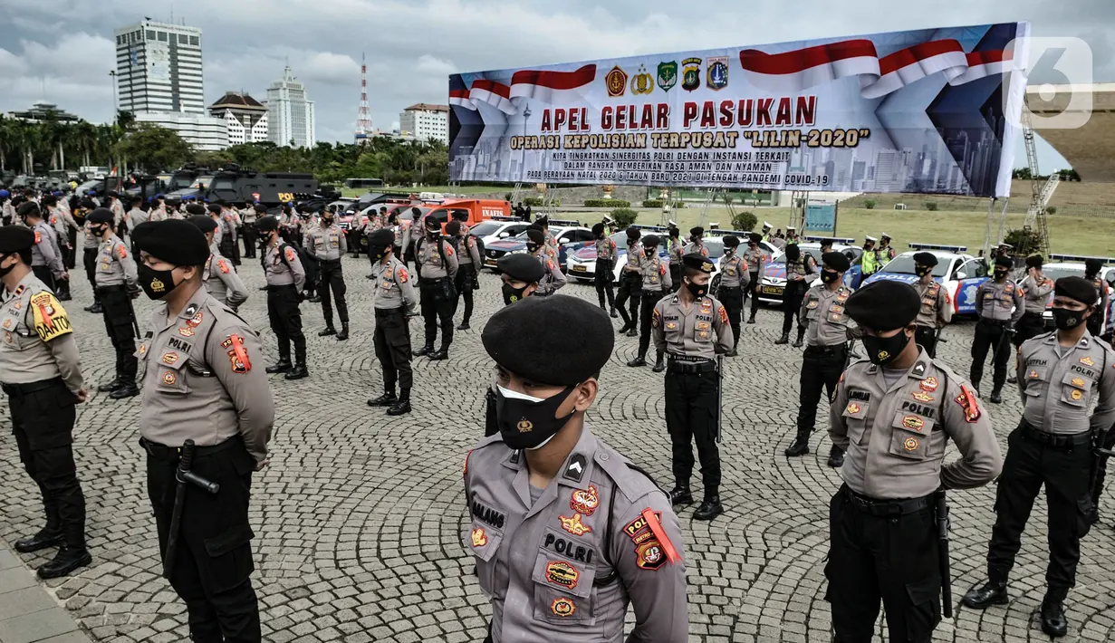 Personel polisi mengikuti apel Operasi Lilin Jaya 2020 di Lapangan Silang Monas, Jakarta, Senin (21/12/2020). Tugas kepolisian di momen Natal 2020 dan Tahun Baru 2021 selain memastikan keamanan dari tindak kejahatan, juga mengawasi pelanggaran protokol kesehatan. (merdeka.com/Iqbal S. Nugroho)