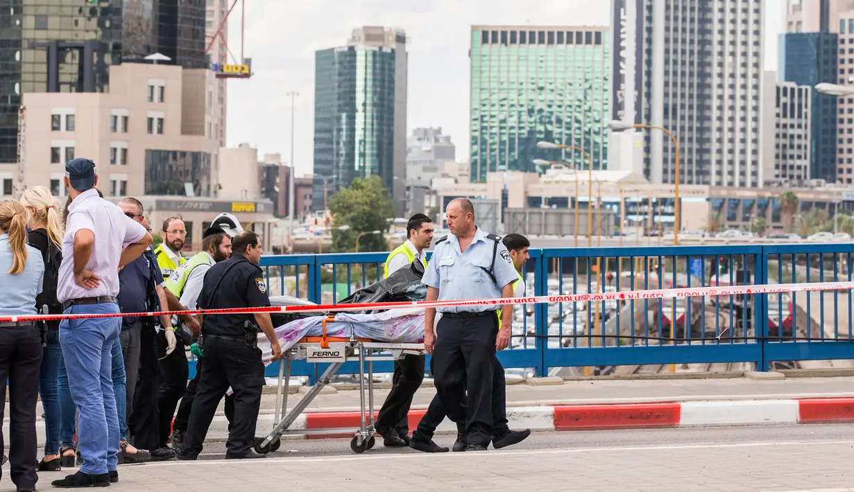 Petugas membawa mayat pria Palestina yang ditembak mati usai menikam dua warga Israel di Tel Aviv, Kamis (8/10). Menurut juru bicara polisi Israel, pria Palestina itu menikam tentara wanita dengan obeng di Mulailah Street. (AFP PHOTO/JACK GUEZ)
