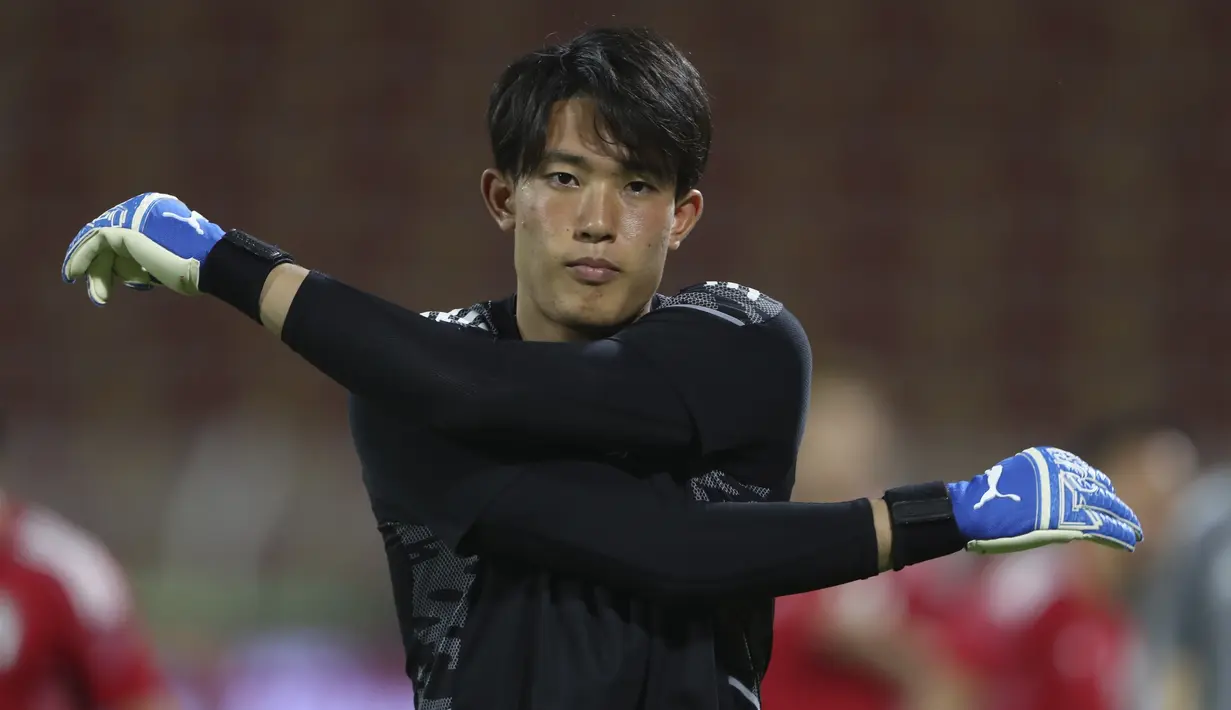 Penjaga gawang Jepang Kosei Tani melakukan pemanasan selama latihan di Muscat, Oman, Senin (15/11/2021). Jepang akan bertanding melawan tuan rumah Oman pada Kualifikasi Piala Dunia 2022 zona Asia di Stadion Qaboos Sports Complex. (AP Photo/Kamran Jebreili)