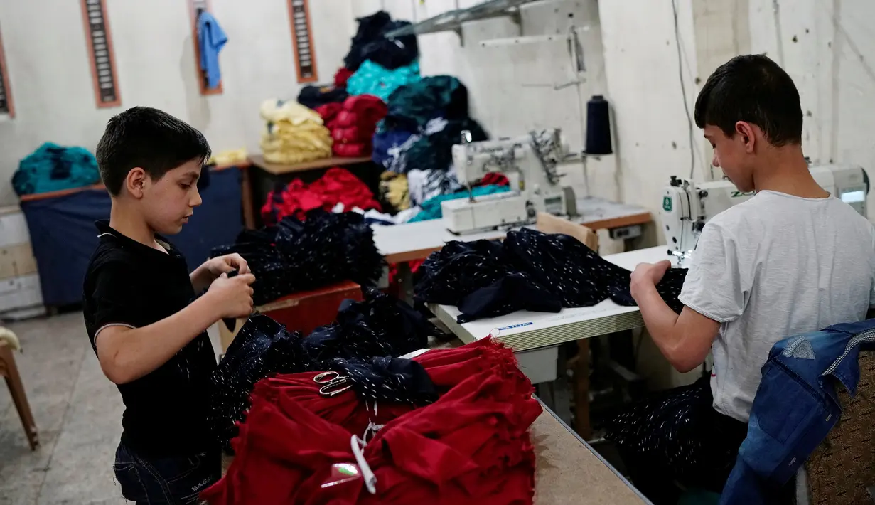 Bocah pengungsi Suriah sedang bekerja sebuah pabrik tekstil di Gaziantep, Turki, (16/5). Mereka bekerja untuk membantu orang tuanya untuk hidup selama mengungsi di Turki. (REUTERS/Umit Bektas)
