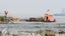 Petugas Dinas Kebersihan membersihkan sampah di pesisir Muara Angke, Jakarta, Kamis (29/10). Petugas menggunakan perahu untuk membersihkan sampah dari kawasan Muara Baru hingga Pantai Indah Kapuk. (Liputan6.com/Faizal Fanani)