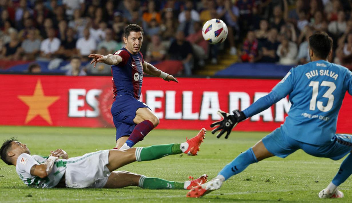 Pemain Barcelona, Robert Lewandowski, berusaha mencetak gol ke gawang Real Betis pada laga Liga Spanyol di Estadi Olimpic Lluis Companys, Minggu (17/9/2023). Barca menang dengan skor 5-0. (AP Photo/Joan Monfort)